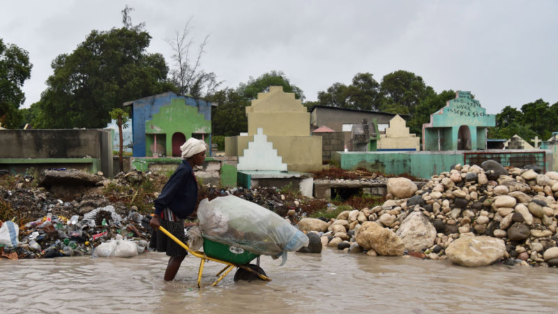 Una mujer empuja una carretilla a través de una calle inundada en la capital de Haití. La foto fue tomada el 4 de octubre. (Foto: Getty).